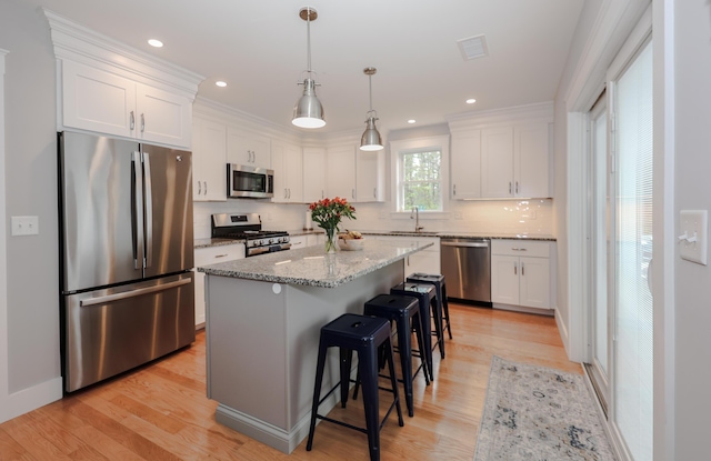 3 Jennifer Ln Unit 1, Wells, ME 04090 - kitchen featuring appliances with stainless steel finishes, white cabinetry, a kitchen bar, light wood-type flooring, and recessed lighting