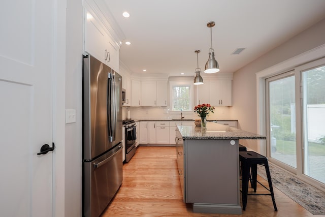 3 Jennifer Ln Unit 1, Wells, ME 04090 - kitchen with appliances with stainless steel finishes, a breakfast bar area, light wood-type flooring, white cabinets, and a kitchen island