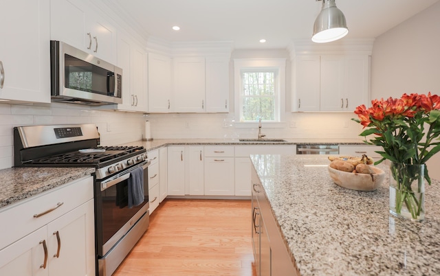 3 Jennifer Ln Unit 1, Wells, ME 04090 - kitchen featuring appliances with stainless steel finishes, white cabinets, light wood finished floors, light stone counters, and recessed lighting