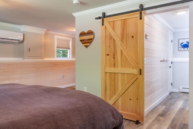 18 Brian Dr, Brewer, ME 04412 - bedroom featuring a wall mounted AC, a baseboard heating unit, crown molding, a barn door, and wood finished floors