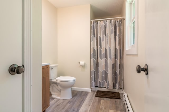 18 Brian Dr, Brewer, ME 04412 - full bath featuring baseboard heating, wood finished floors, toilet, vanity, and a shower with curtain