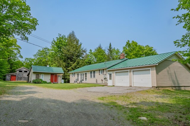 52 Judkins Rd, Harmony, ME 04942 - ranch-style home with a chimney, metal roof, a front lawn, a standing seam roof, and asphalt driveway