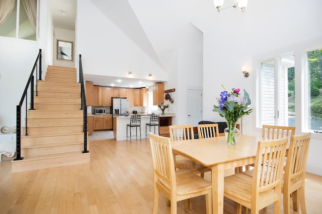 2301 State Route 129, South Bristol, ME 04568 - dining area with high vaulted ceiling, stairway, and light wood-style floors