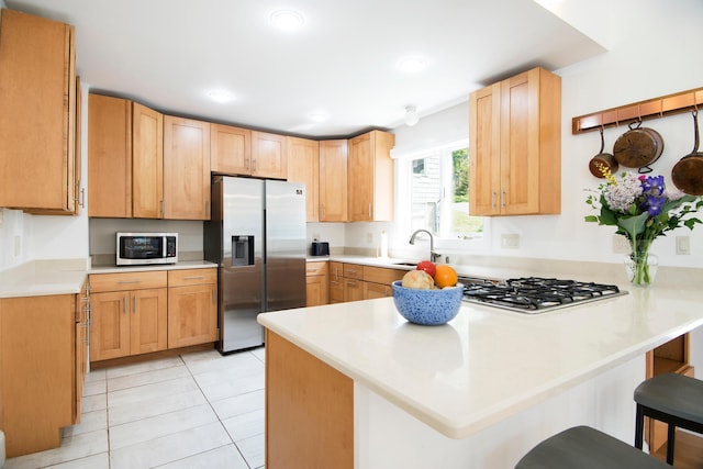 2301 State Route 129, South Bristol, ME 04568 - kitchen featuring stainless steel appliances, a peninsula, a kitchen breakfast bar, light countertops, and light tile patterned floors