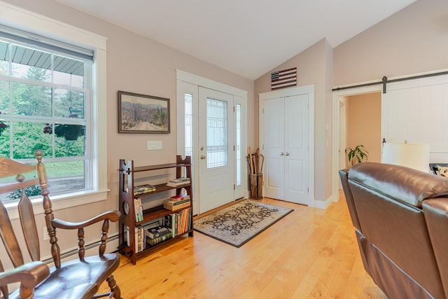 2 Neptune Rd, Old Orchard Beach, ME 04064 - foyer entrance with lofted ceiling, healthy amount of natural light, light wood-type flooring, a barn door, and baseboards