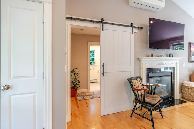 2 Neptune Rd, Old Orchard Beach, ME 04064 - sitting room with hardwood / wood-style flooring, a wall mounted air conditioner, a baseboard heating unit, a fireplace with flush hearth, and a barn door