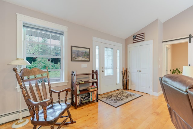 2 Neptune Rd, Old Orchard Beach, ME 04064 - entrance foyer with a barn door, light wood-style floors, lofted ceiling, baseboards, and a baseboard heating unit
