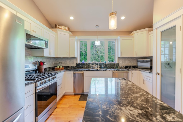 2 Neptune Rd, Old Orchard Beach, ME 04064 - kitchen with appliances with stainless steel finishes, decorative backsplash, dark stone countertops, light wood finished floors, and recessed lighting