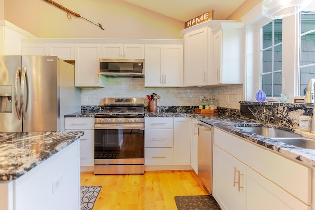 2 Neptune Rd, Old Orchard Beach, ME 04064 - kitchen featuring stainless steel appliances, a sink, light wood-type flooring, white cabinets, and tasteful backsplash