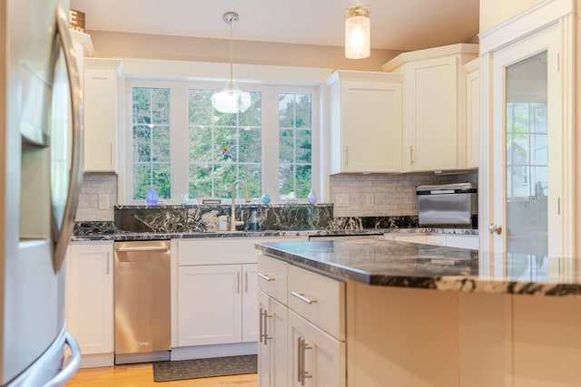 2 Neptune Rd, Old Orchard Beach, ME 04064 - kitchen with freestanding refrigerator, backsplash, dark stone countertops, and white cabinetry