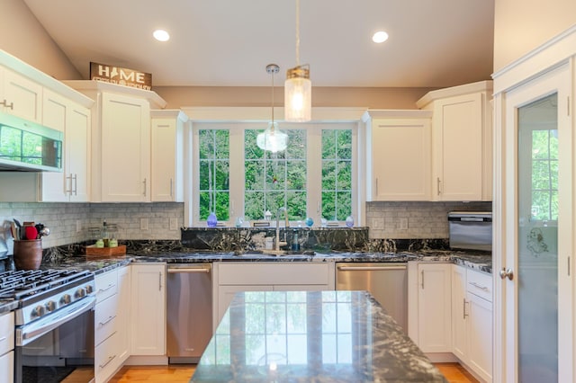 2 Neptune Rd, Old Orchard Beach, ME 04064 - kitchen with appliances with stainless steel finishes, dark stone countertops, white cabinets, recessed lighting, and hanging light fixtures