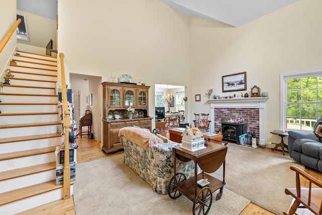 30 Oliver Woods Rd, Nobleboro, ME 04555 - living area with high vaulted ceiling, stairs, light wood-style flooring, a chandelier, and a wood stove
