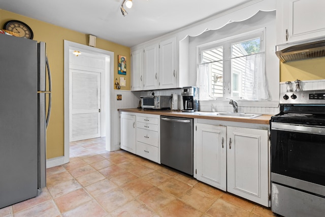 194 Margaret St, South Portland, ME 04106 - kitchen with appliances with stainless steel finishes, under cabinet range hood, and white cabinets