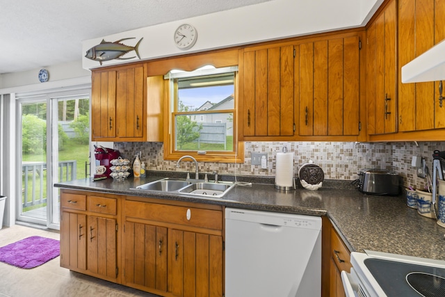 2 Laase Ave, Lewiston, ME 04240 - kitchen with white dishwasher, backsplash, and brown cabinets