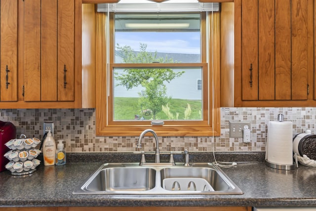2 Laase Ave, Lewiston, ME 04240 - kitchen featuring brown cabinetry, dark countertops, and backsplash
