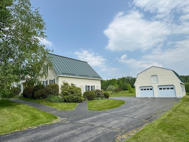 124 Swan Rd, Hermon, ME 04401 - view of side of property with a standing seam roof, a lawn, an outdoor structure, a garage, and metal roof