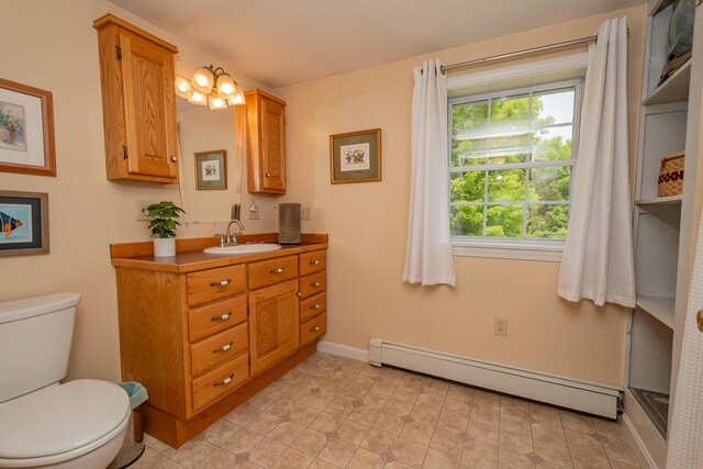 52A Judkins Rd, Harmony, ME 04942 - bathroom with a baseboard heating unit, vanity, toilet, and baseboards