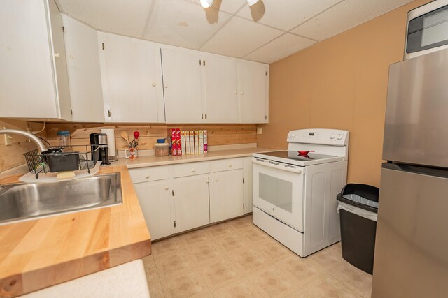 52A Judkins Rd, Harmony, ME 04942 - kitchen with white range with electric cooktop, freestanding refrigerator, a paneled ceiling, a sink, and light countertops