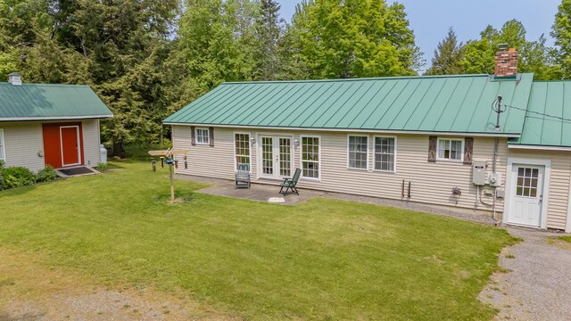52A Judkins Rd, Harmony, ME 04942 - back of house featuring a chimney, a yard, metal roof, a patio area, and a standing seam roof
