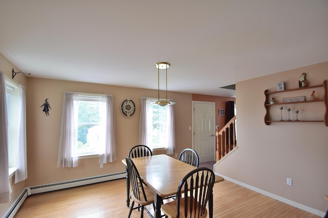 31 Curtis St, South Portland, ME 04106 - dining area with light wood finished floors, stairway, and a baseboard radiator