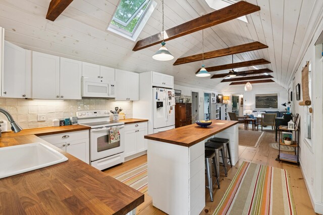 74 Ottawa Ave, Portland, ME 04109 - kitchen featuring butcher block counters, white appliances, a skylight, light wood-type flooring, and a breakfast bar area
