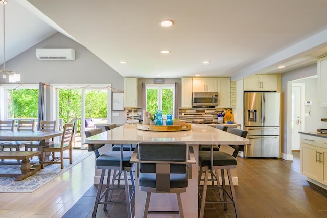 42 Barter Rd, Rockland, ME 04841 - kitchen featuring stainless steel appliances, a wall mounted AC, a kitchen island, a kitchen breakfast bar, and vaulted ceiling