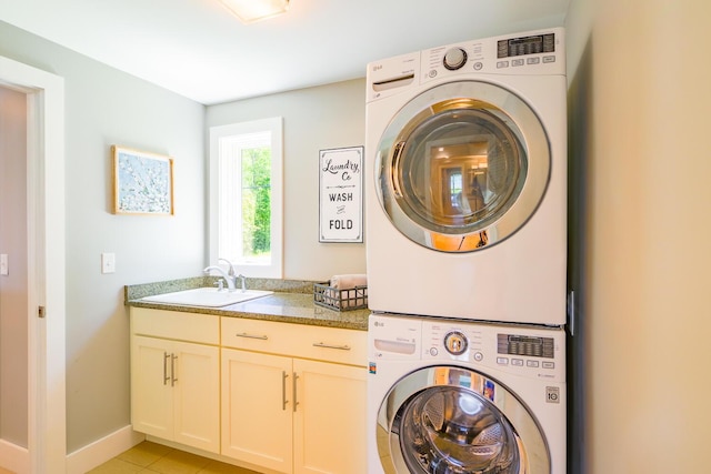 42 Barter Rd, Rockland, ME 04841 - laundry room featuring estacked washer and dryer, cabinet space, and light tile patterned floors