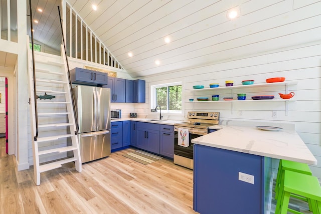 42 Barter Rd, Rockland, ME 04841 - kitchen with appliances with stainless steel finishes, blue cabinetry, lofted ceiling, light wood-type flooring, and light stone countertops