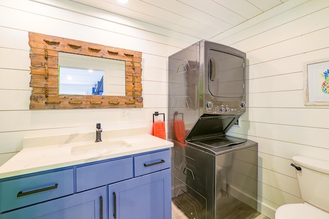 42 Barter Rd, Rockland, ME 04841 - bathroom featuring estacked washer and dryer, wooden walls, vanity, and wood finished floors