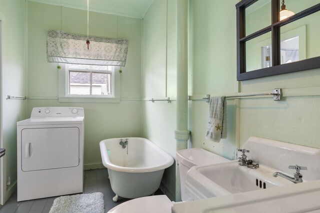 10 S Colony Branch Rd, Harpswell, ME 04079 - bathroom with washer / clothes dryer, a freestanding bath, and toilet