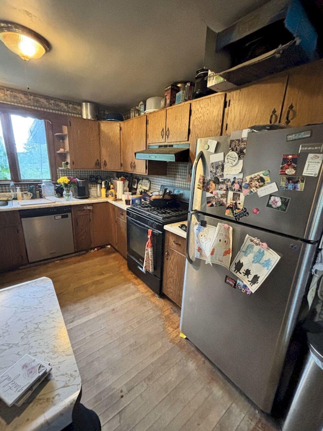 118 Athens Rd, Hartland, ME 04943 - kitchen with stainless steel appliances, under cabinet range hood, light wood-style floors, light countertops, and brown cabinets
