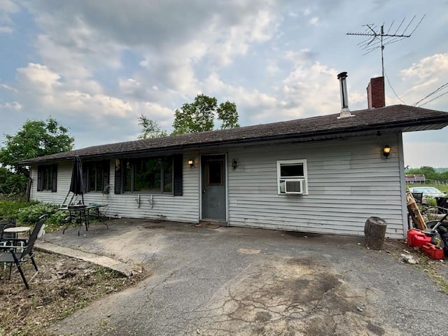 118 Athens Rd, Hartland, ME 04943 - view of front facade featuring a chimney, a patio area, and cooling unit