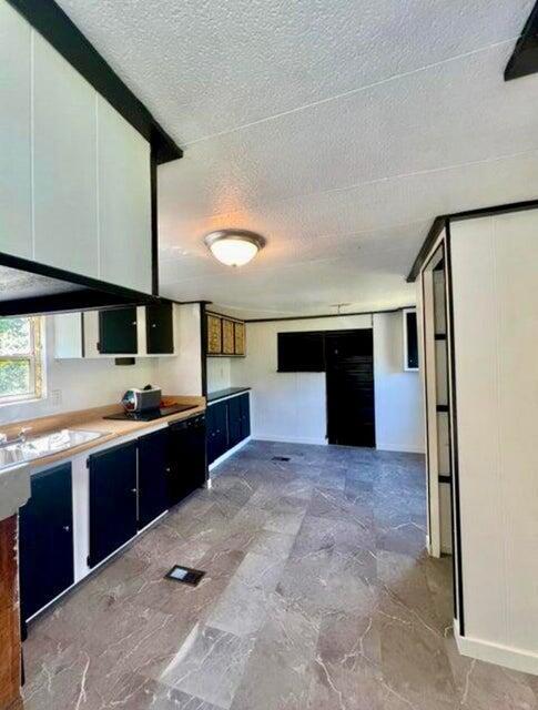 105 Arthur Allen Rd, Sumner, ME 04292 - kitchen with a textured ceiling, light countertops, and a sink