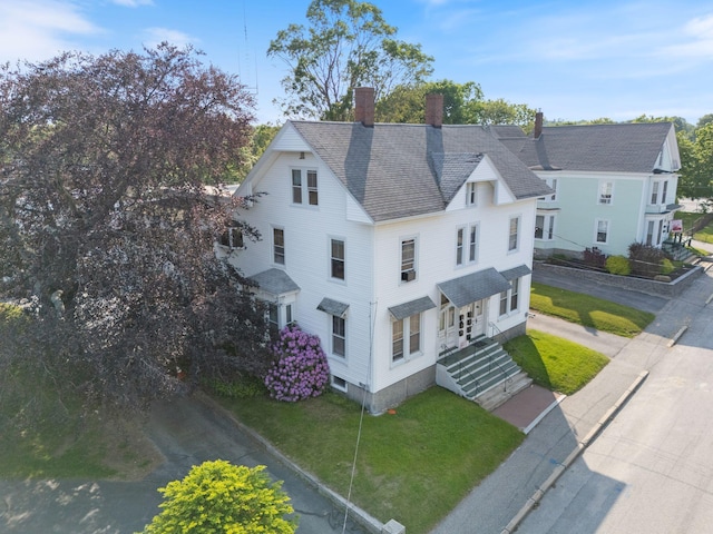 34 Birch St, Biddeford, ME 04005 - view of front facade with a chimney, a front yard, and roof with shingles