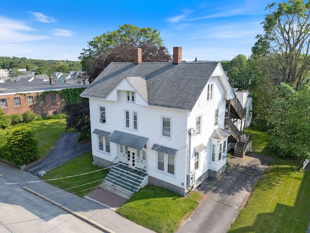 34 Birch St, Biddeford, ME 04005 - view of front facade featuring stairs, a chimney, roof with shingles, a front yard, and driveway
