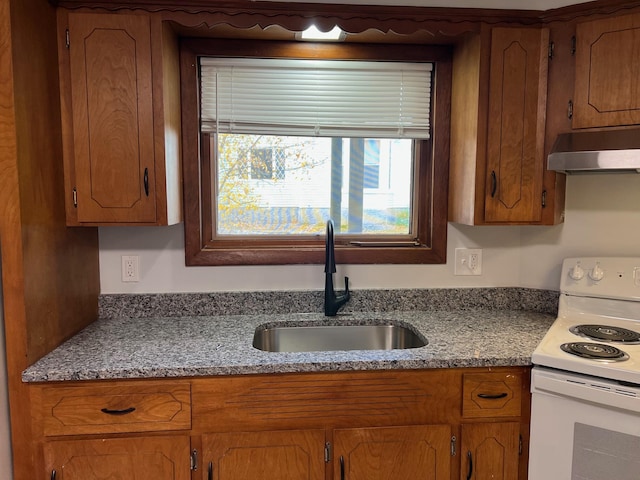 34 Birch St, Biddeford, ME 04005 - kitchen featuring electric range, under cabinet range hood, a sink, and brown cabinets