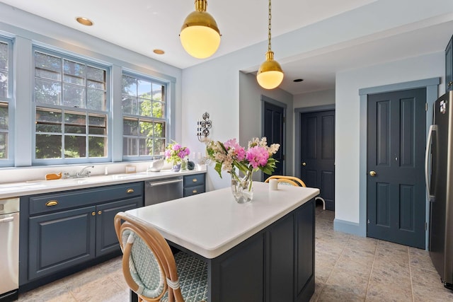33 Rocky Ln, Ogunquit, ME 03907 - kitchen with appliances with stainless steel finishes, light countertops, pendant lighting, a kitchen island, and blue cabinets