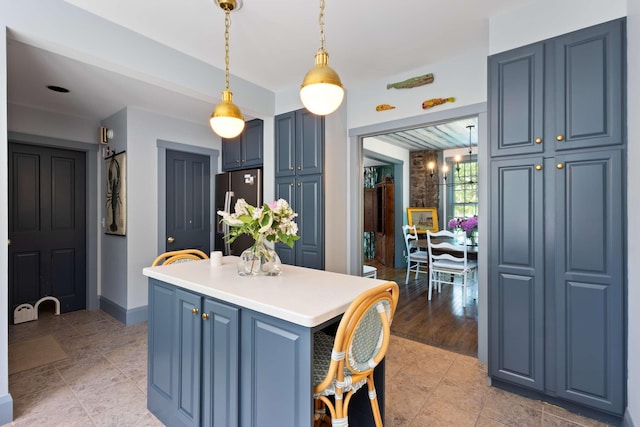 33 Rocky Ln, Ogunquit, ME 03907 - kitchen with freestanding refrigerator, blue cabinets, pendant lighting, and a center island
