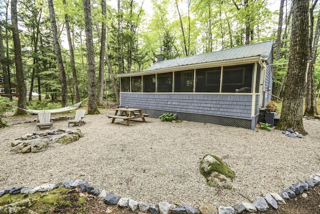 7 Cluff Ln, Bridgton, ME 04009 - rear view of property featuring a sunroom, a chimney, and metal roof