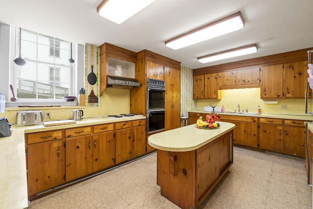 85 Friendship Rd, Waldoboro, ME 04572 - kitchen with light countertops, light floors, exhaust hood, and brown cabinetry