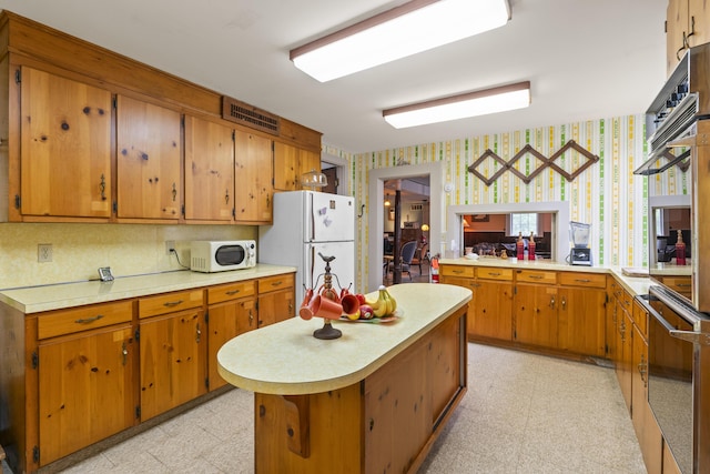 85 Friendship Rd, Waldoboro, ME 04572 - kitchen featuring white appliances, wallpapered walls, light floors, light countertops, and brown cabinets