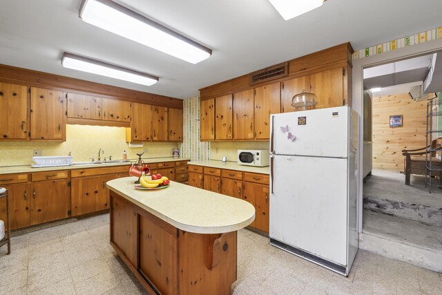 85 Friendship Rd, Waldoboro, ME 04572 - kitchen with white appliances, light countertops, brown cabinets, light floors, and wooden walls