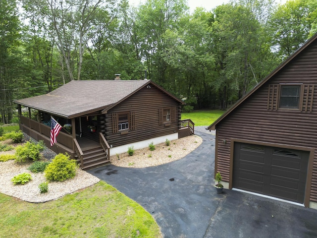 509 Upper Guinea Rd, Lebanon, ME 04027 - view of front facade with a porch, driveway, log exterior, and roof with shingles