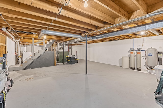 509 Upper Guinea Rd, Lebanon, ME 04027 - unfinished basement featuring a water softener system, a water pressure tank, stairs, and heating unit