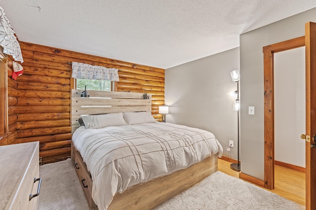 509 Upper Guinea Rd, Lebanon, ME 04027 - bedroom with a textured ceiling, rustic walls, and light wood-style flooring