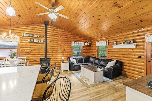 509 Upper Guinea Rd, Lebanon, ME 04027 - living area featuring a wood stove, vaulted ceiling, a chandelier, light wood finished floors, and a ceiling fan