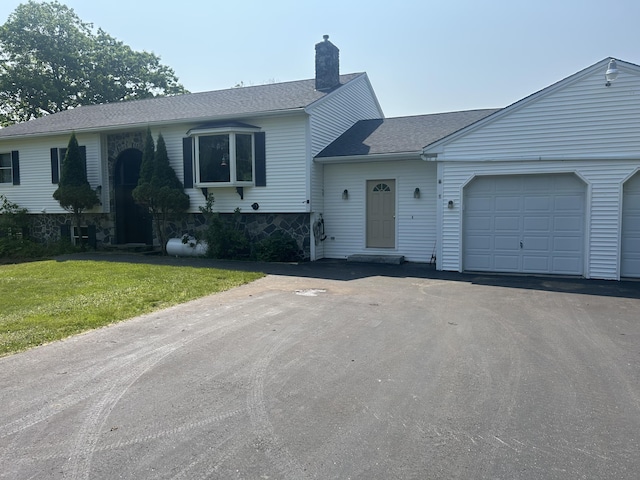 8 Camp Rd, Hartford, ME 04220 - view of front of property featuring a garage, asphalt driveway, a chimney, a front yard, and a shingled roof