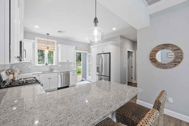 46 Patriot Way Unit 135, Arundel, ME 04046 - kitchen with appliances with stainless steel finishes, a sink, a peninsula, baseboards, and backsplash