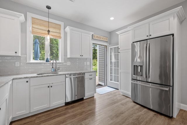 46 Patriot Way Unit 135, Arundel, ME 04046 - kitchen with appliances with stainless steel finishes, a sink, white cabinets, backsplash, and healthy amount of natural light