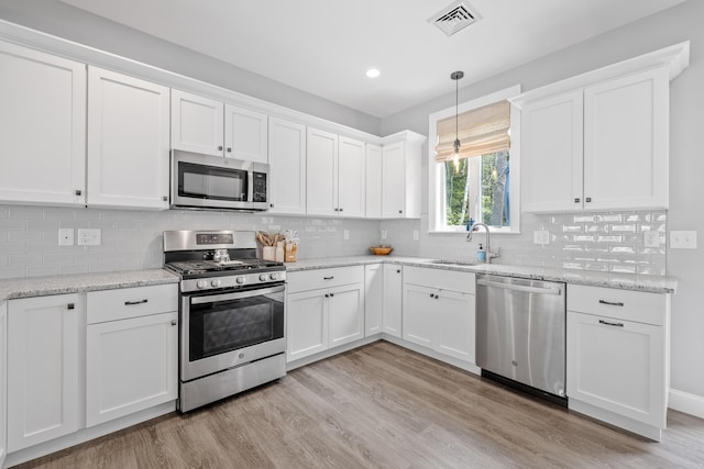 46 Patriot Way Unit 135, Arundel, ME 04046 - kitchen with stainless steel appliances, a sink, light wood-style floors, white cabinetry, and recessed lighting